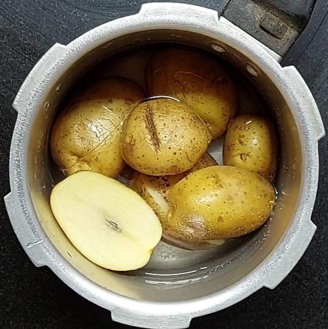 Wash and slice 5-6 potatoes. Transfer to a cooker, add 2 cups of water and salt to taste. Close the lid and take 3 whistles. Switch off the flame and let the pressure of the cooker release naturally.