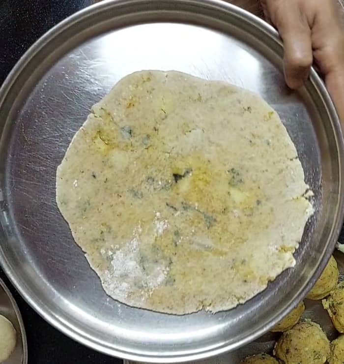 Start rolling the. paratha by dusting flour in between. Roll a slightly thick paratha. Transfer to a plate.