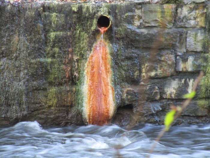 Mineral spring runoff into Geyser creek, with mineral formation on the rock wall.