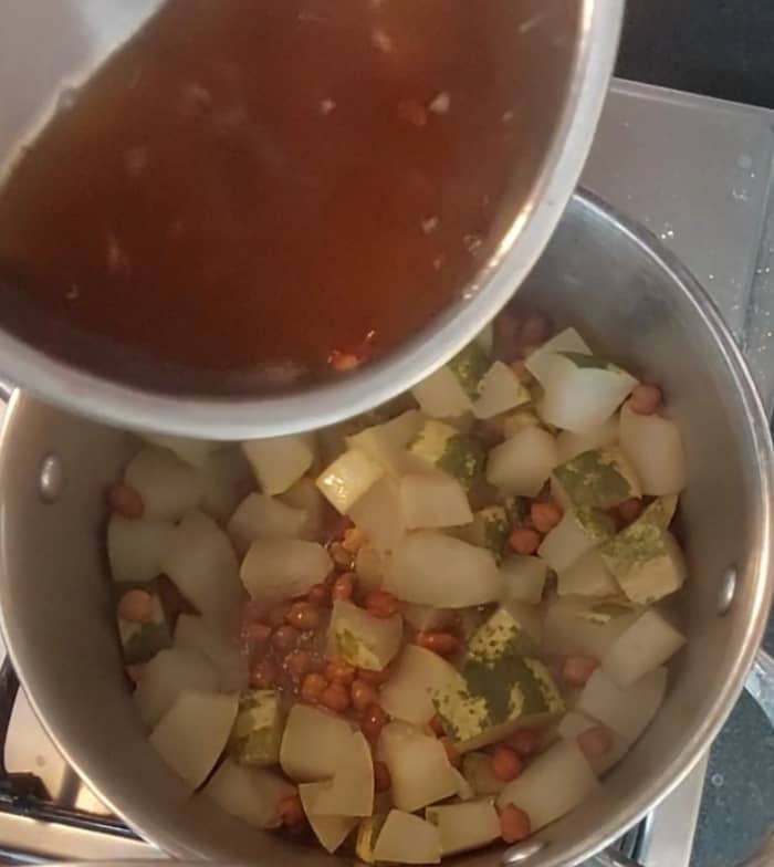 After cucumber and chana are well cooked, squeeze the tamarind into the water and add the tamarind water to the cooked vegetable. Discard the residue.