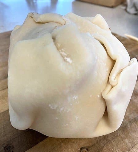 Bring the corners of the dough up and over the apple to meet at the top. Fold the sides around the apples, being careful to not squeeze the apple with the pressure.
