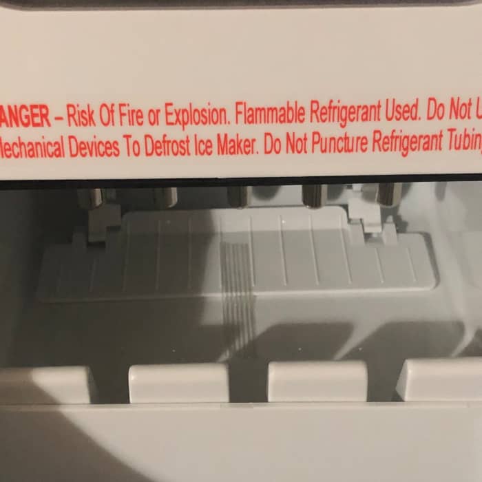 Don't forget to remove this piece of tape in the back! Then, let your ice maker sit on the counter for a few hours to let the refrigerant settle inside.