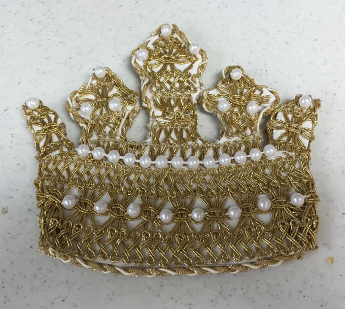 The crown goes on top of the Chrismon tree, in place of the star, angel, or large bow that would be on a secular tree.