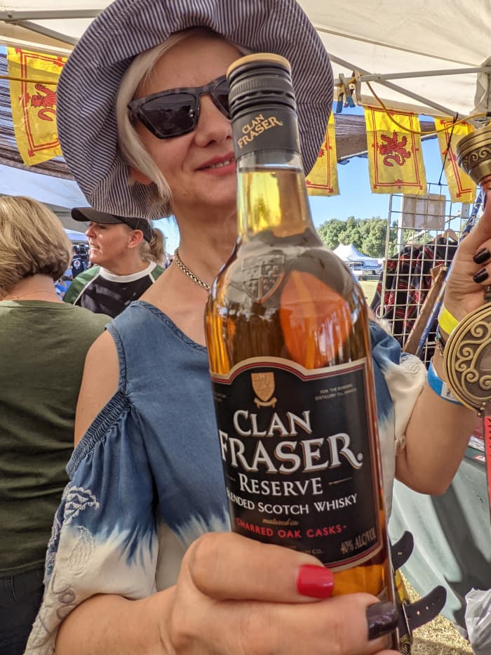My wife with the bottle of Clan Fraser whisky we purchased