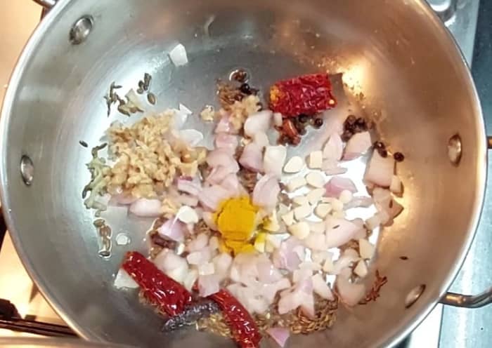 Add 1 chopped onion, 2 teaspoons grated ginger, 5-6 chopped garlic cloves and 1/4 teaspoon turmeric powder. Saute for 1 minute.