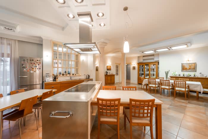 A Leo kitchen has tones of yellow, brown, and orange. There is communal space and the area comes off as energetic.