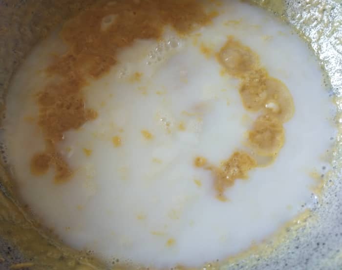 Now add 1 cup of milk+1 cup of water. Mix and continue to stir in low flame so that lumps are not formed.