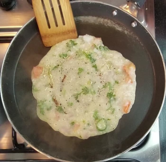 Sprinkle a few drops of ghee over the chilla, close the lid and cook for 1 minute over medium flame.