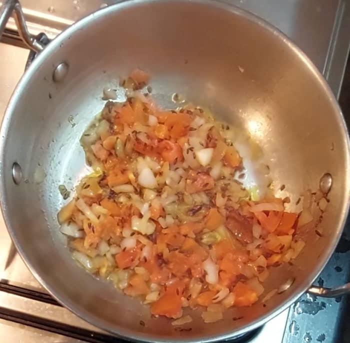 Add 1 cup chopped tomato and saute till it shrinks. Close the lid and cook over low flame for 2 minutes.