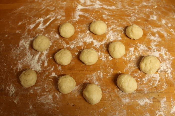Divide the dough in half, then in half again and again until you have 12 chunks of dough. Roll each chunk into a ball of dough.