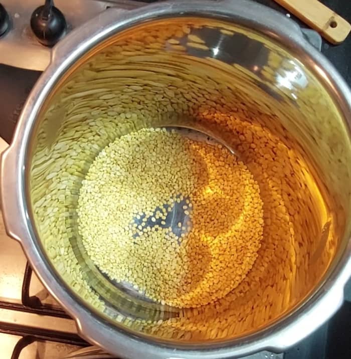 In a cooker, dry-fry 1/2 cup moong dal (split green gram) till dal turns aromatic. Do not burn. Switch off the flame.