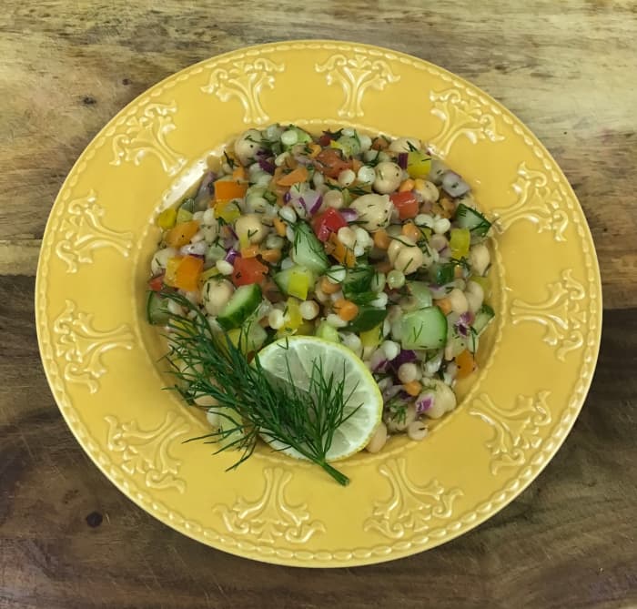 A refreshingly light yet filling salad with couscous, chickpeas, red onion, bell peppers, cucumber, and a light lemon vinaigrette.