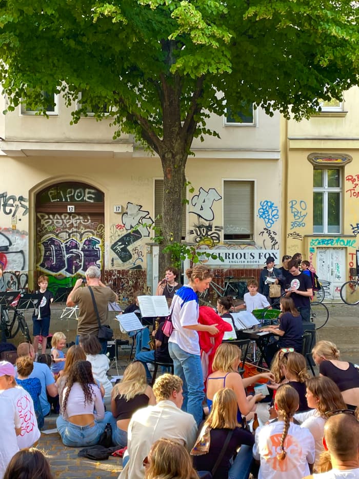 Lausitzer Platz on a nice sunny day. It is the Day of Music and people are listening to a small orchestra among several from the area. The square is frequently used for markets and street festivals.