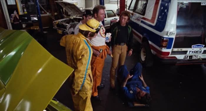 Moose (Roger Ward) gives Larry (Steve Bisley- far right) some marital advice as he prepares to head off on a weekend getaway