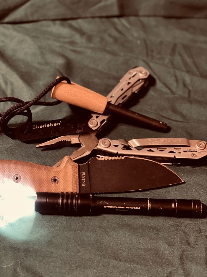 Essential tools—überleben Zünden Fire Starter, Gerber Suspension NXT, RAT 3 Ontario, and Streamlight ProTac.