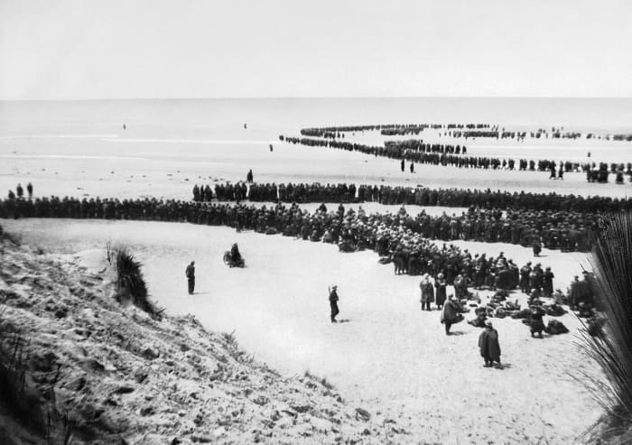 British troops line up on the beach at Dunkirk to await the evacuation of over 338,000 Allied soldiers from the beaches and harbor of Dunkirk in northern France, May 26, 1940. By June 4,1940, the evacuation of Allied forces was completed.