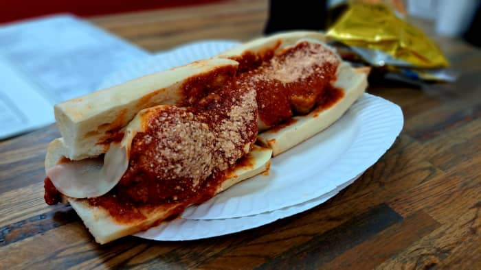 A meatball parmigiana sub featuring a fresh Formica Bakery roll and handmade meatballs with tomato gravy and melted provolone and Parmesan.