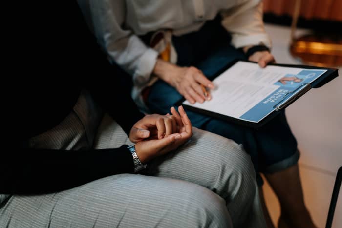 A person reviews a resume on a clipboard with someone. Making small changes on your resume can help you stand out from the hundreds of applicants you're competing against.
