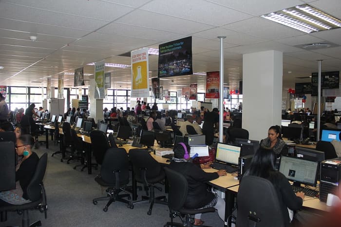 Open floor office shows elbow-to-elbow seating, which is common in many call centers. Customer support jobs are one of the most outsourced occupations in the West, in turn creating more demand for call centers overseas.
