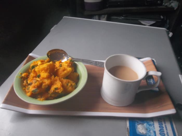 A yam porridge cooked with red palm oil, onions, spring onions, parsley, sage, and fresh pepper. A cup of milk tea supply animal protein.