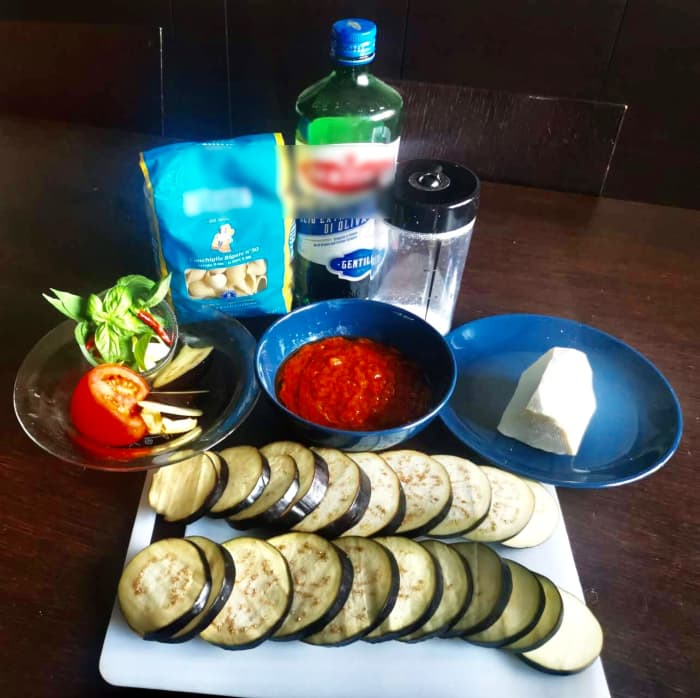 The main ingredients used for this recipe are pasta, extra virgin olive oil, tomato puree, ricotta salata, chili peppers, and eggplants.
