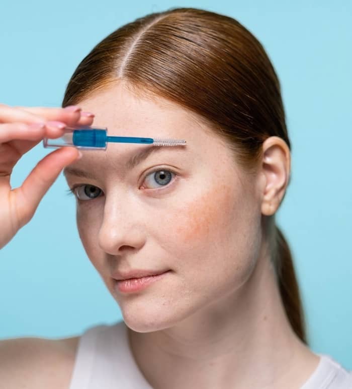 Using a brush applicator, smooth castor oil on your brows to promote hair growth and smooth stray brows for a neat and clean effect. Tweeze any stray hairs around the brow line.