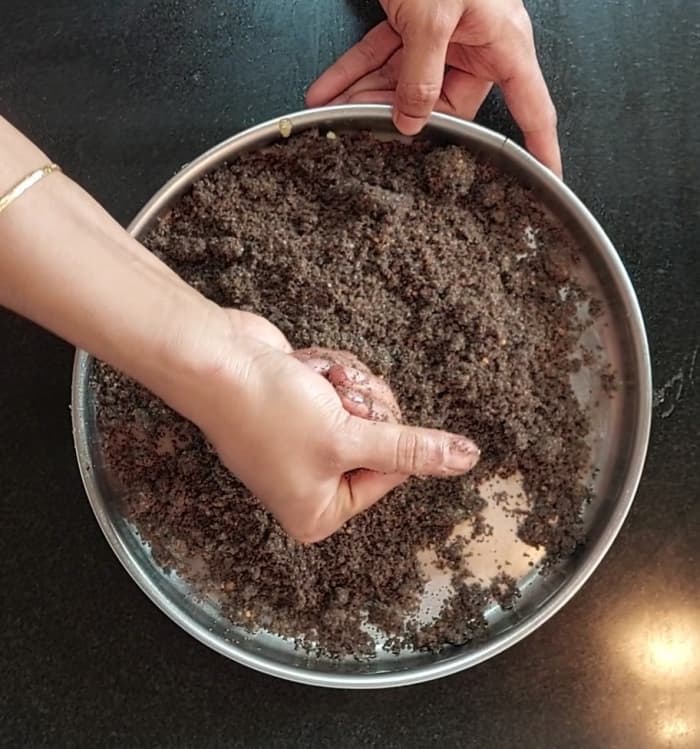 Take a small portion of this mixture and form a laddu using your hands. It will bind well without breaking.