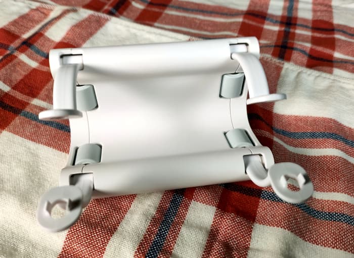 The two sets of arms connect when pressed together. This action fully surrounds the curtain rod and provides a set of holes used to attach the driver's hooks