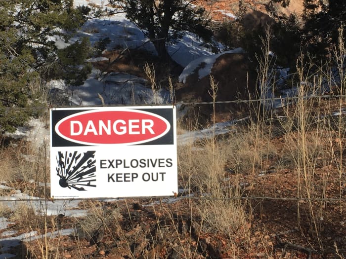 Explosives warning sign at the perimeter fence of the National Laboratories in Los Alamos, New Mexico. You will see numerous signs like these on your way to Bandelier.