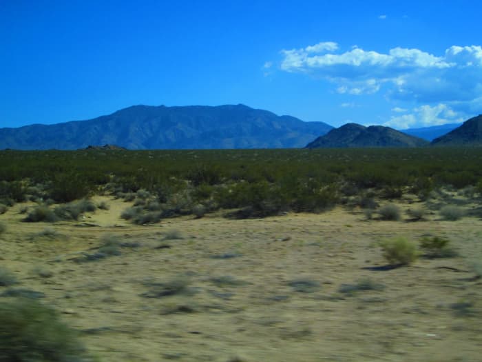 The mountains in the distance are clear, but the sand in the foreground is a bit blurry as we zoom by.
