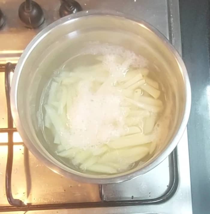Transfer the sliced potatoes to a pot and add water to immerse them completely. Cook for 5 minutes. Do not overcook. Switch off the flame.