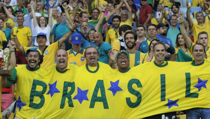 Can any national team match the exploits of Brazil? Here, their fans hold a replica World Cup trophy (left).