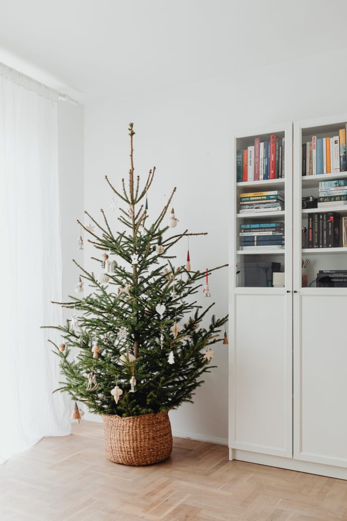 Keep an artificial Christmas tree inside a basket, wheelbarrow, or wagon so you can easily move it around and then store it inside a closet.