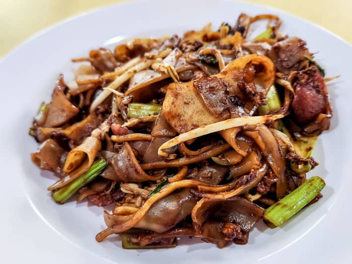 Singaporean Char Kway Teow, or stirred-fried flat rice noodles, is bursting with sweet and savory flavors. It is also prepared using much oil, sweet sauce, and other seasonings. Quiet the nightmare for the health conscious.