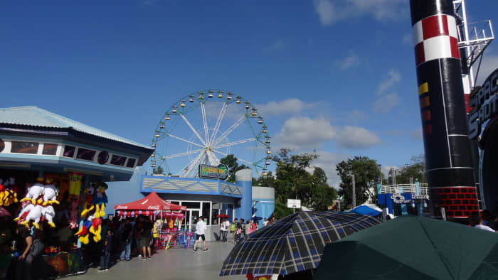 Wheel of Fate, a Ferris wheel in the background. Enchanted Kingdom's slogan is "The Magic Lives Forever!"