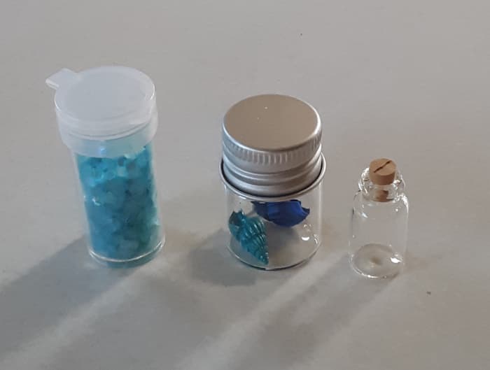 You will need aqua or blue Hexagon glitter, painted seashells, and tiny bottle to create this magical ocean craft.