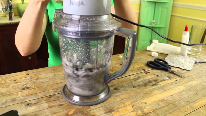 Torn up paper and lint is added into a blender with plenty of water. It is then blended until smooth.