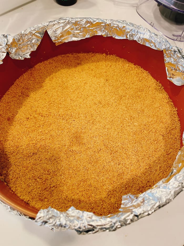 Place the mixture into the prepared pan. Press the mixture into the bottom evenly with your hand or spatula.