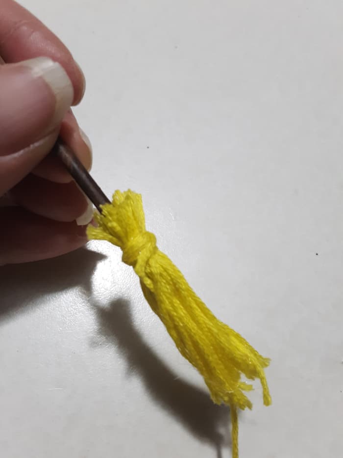 Wrap one end of string all around, if you use the same color yarn, it won't be necessary to cut ends off.