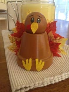 Clay pot, doll head, paint, felt for for feet and beak, and fake fall leaves from the dollar store. Hot glue everything to together.