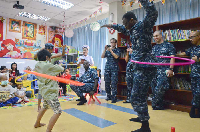 Sailors from the U.S. Navy volunteer at a children's hospital library.