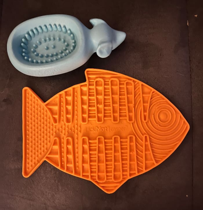 Lick mats and toys like the ones picture here have lots of nooks & crannies which will significantly slow down how quickly your cat can eat their food.