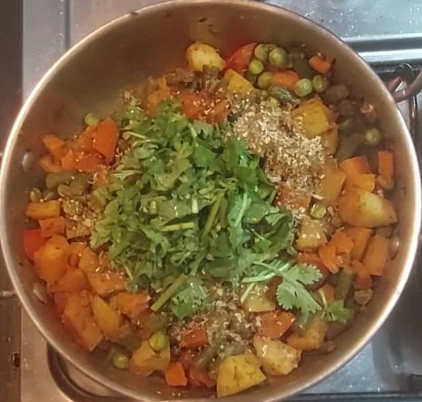Open the lid and check if water dried completely and if vegetables are cooked well. If not, cook for some more time. Do not overcook the vegetables. Adjust salt. Add 2 teaspoons mixed herbs, 1/4 cup chopped coriander leaves.