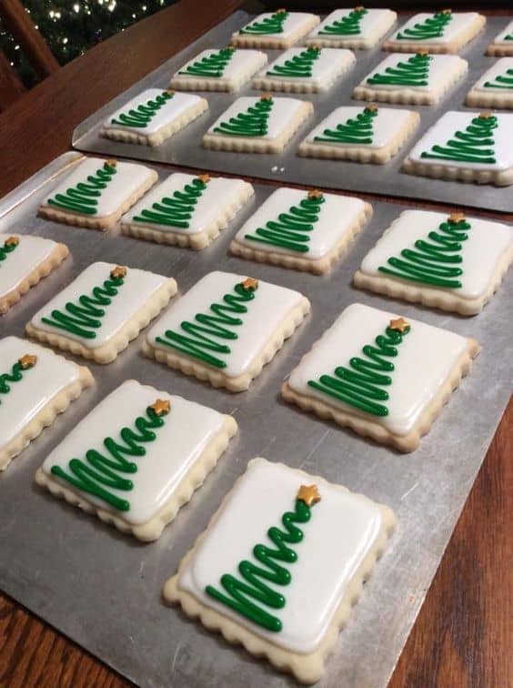 Check out these lovely Christmas tree sugar cookies! Bake and cool sugar cookies. With royal icing, pipe a dam around the edges, then fill with icing and smooth. When set, pipe a royal icing or gel tree. Add star. Let set. Looks easy!