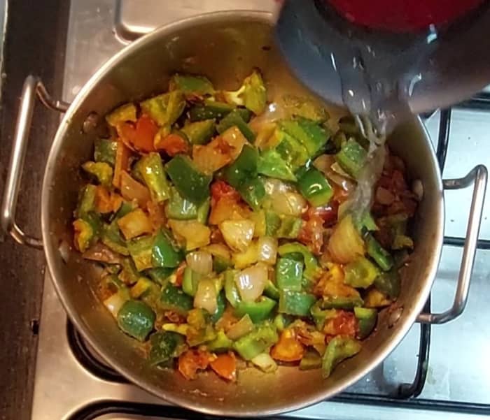 Saute well till capsicum shrinks. Add salt to taste. Mix once. Add 1/4 cup water, close the lid and cook for 3 minutes.