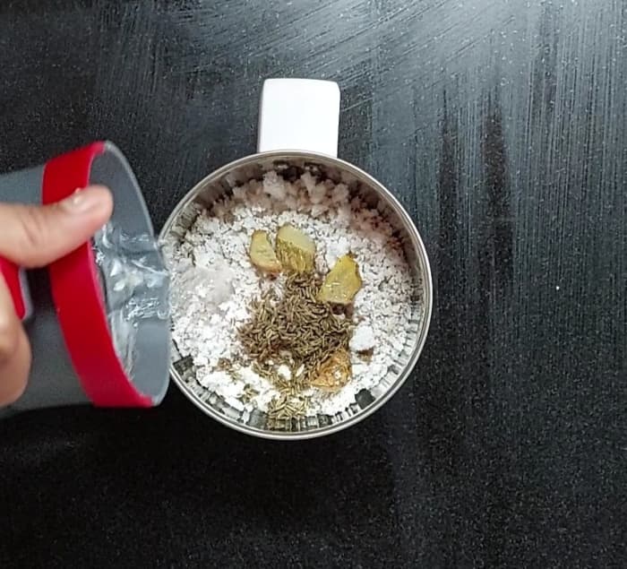 In a mixer jar, add 1 cup grated fresh coconut, a 2-inch-long piece of ginger, 1 teaspoon cumin seeds and 1/4 cup of water.