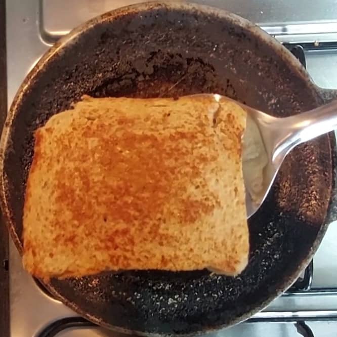 Heat tawa, drizzle some drops of ghee over tawa, place sandwich over hot tawa, drizzle few more drops of ghee on sandwich, fry till golden brown. Flip and fry o other side too. Add more ghee if required. Once done, transfer to the plate.