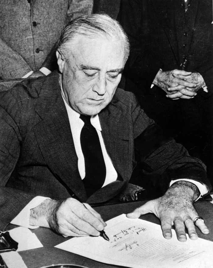 President Franklin Roosevelt signing a declaration of war against Japan on December 8th, 1941. The declaration officially brought the United States into World War II.