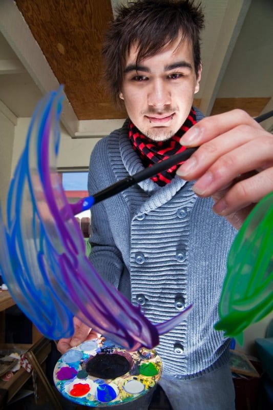 An artist paints on glass. Discover some ideas for selling your artwork, from drawing caricatures to designing t-shirts.