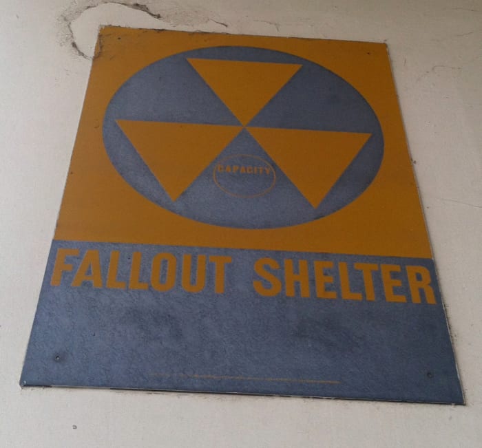 A sign indicating a fallout shelter at a government facility. Look for these signs anywhere you go so you know where they are.